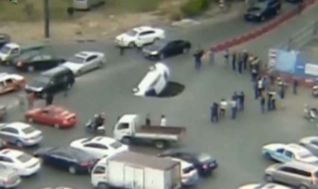 Une voiture happée par un trou en pleine route