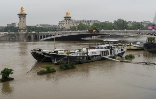 La Seine monte à Paris: berges sous l'eau, une ligne RER et les bateaux à l'arrêt 
